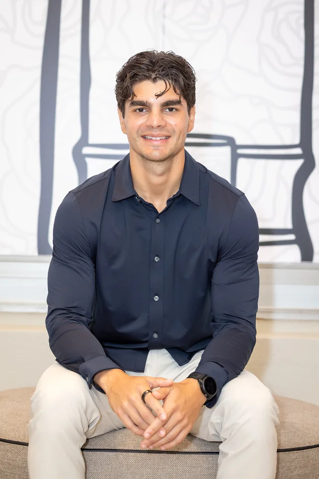 Felix Bravo seated, navy shirt, looking at camera